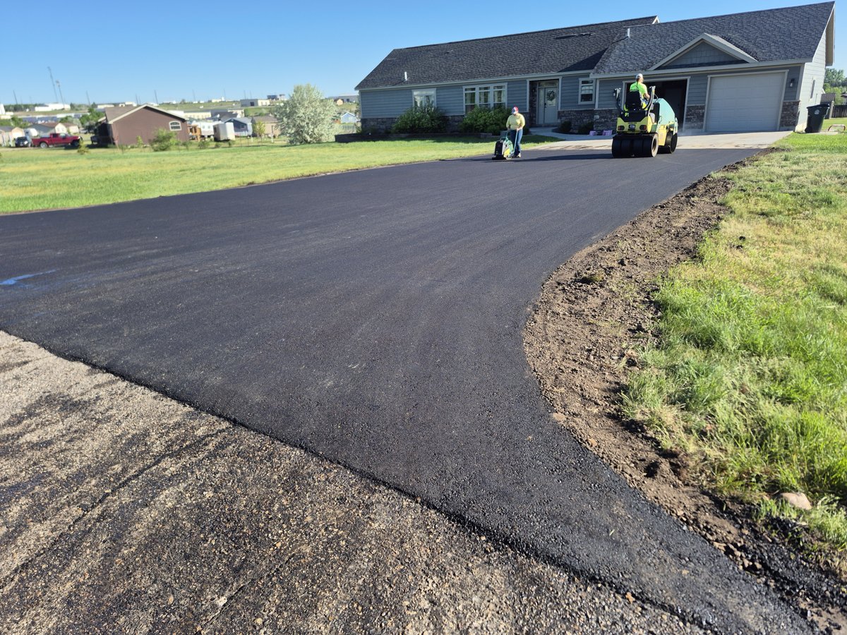 Williston Paving crew rolling fresh asphalt on a driveway